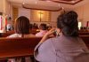 People sitting in church pews during service.