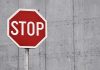 Red stop sign against concrete wall background